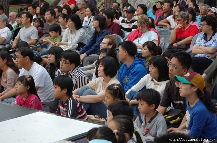 Корейцы и европейцы смотрят представление масок в деревне Хахвэ Республика Корея