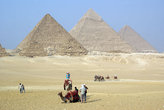 Туристы на верблюдах на фоне пирамид