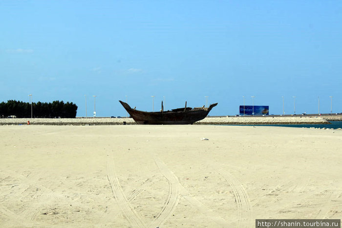 Лодка на берегу. В другом месте такая широкая полоса песка на берегу была бы пляжем. Но не в Бахрейне! Манама, Бахрейн