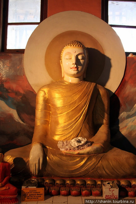 Будда примерно в человеческий рост под гигантской статуей Будды Канди, Шри-Ланка