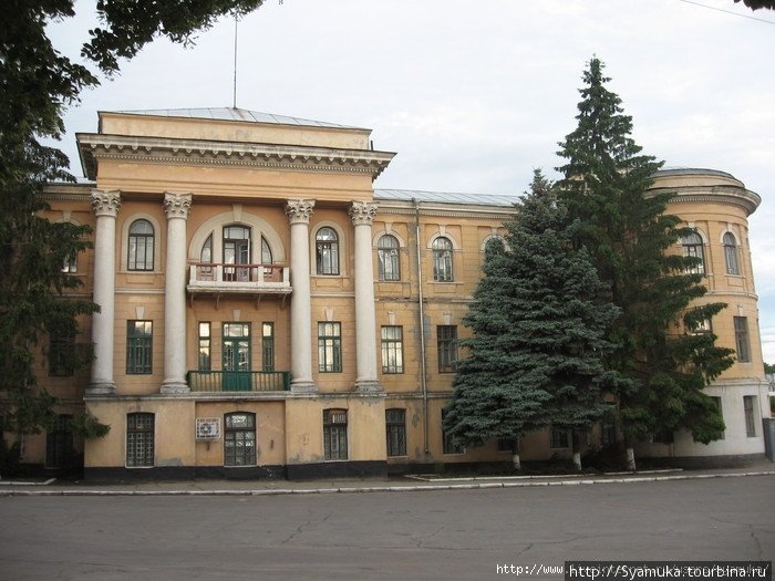 За памятником — большое и красивое здание неправильной формы, построенное в 1928 году как Дом культуры. Первомайск, Украина