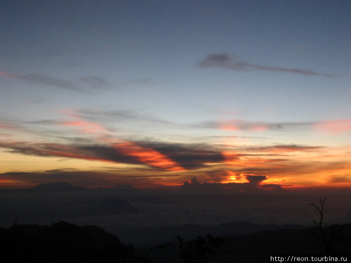 Солнце бросает в разные стороны какие-то фантастические лучи Бромо-Тенггер-Семеру Национальный Парк, Индонезия