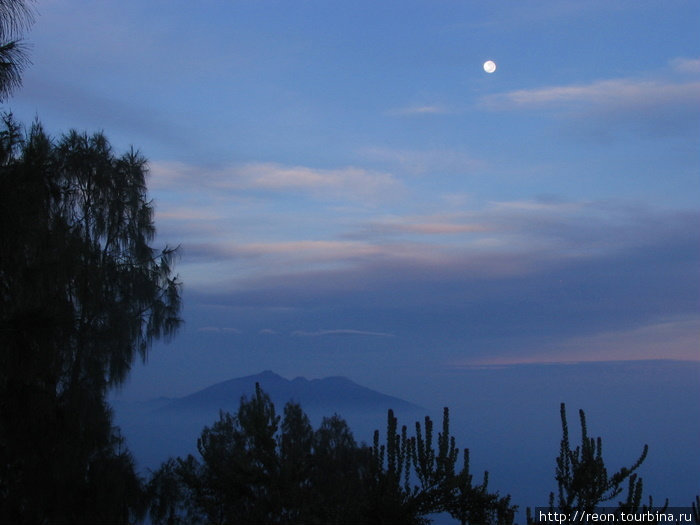 Луна тоже присутствует. Это вид на запад от вулканов Бромо-Тенггер-Семеру Национальный Парк, Индонезия