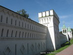 Монастырь обнесен высокой, с одной стороны, снежно-белой, с другой — красно-коричневой, кирпичной стеной, выполненной в различных архитектурных стилях.