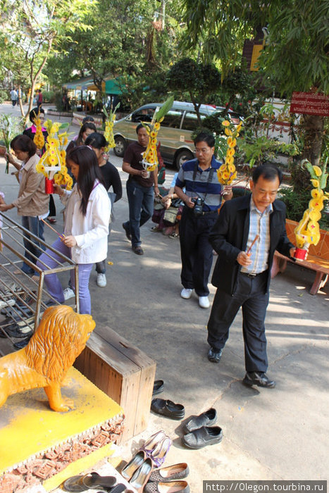 Люди спешат в храм, конечно же, с цветами Вьентьян, Лаос