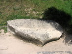 На огромном плоском камне высечено несколько строк странного текста готическим шрифтом. Что именно написано расшифровать не может никто.