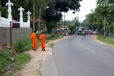 Монахи прогуливаются по дороге перед монастырем