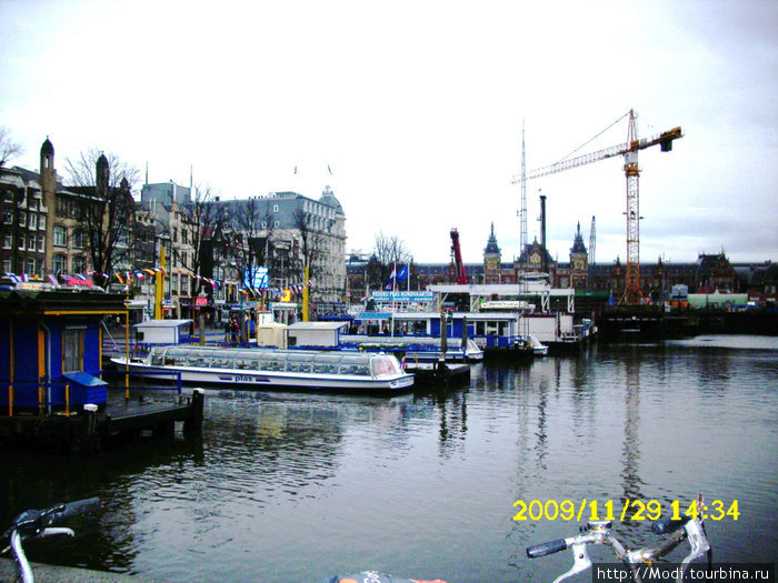 Порт в Амстердаме где стоят прогулочные кораблики Амстердам, Нидерланды