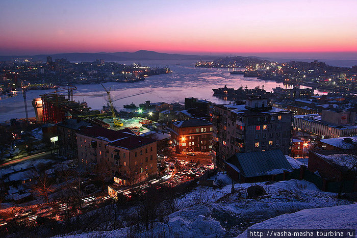 Вид на вечерний город зимой с сопки. Владивосток, Россия