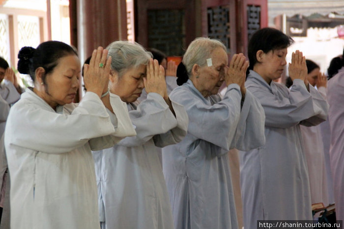 Со сложенными руками стоя в храме Нячанг, Вьетнам