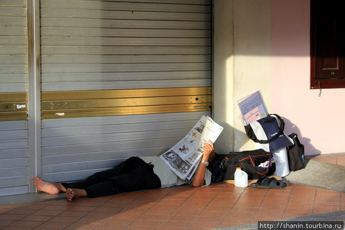Интеллигентный бомж встречает утро 1 января за чтением свежей газеты Сингапур (город-государство)