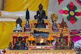 Алтарь со статуэтками богов у ног сидящего Будды