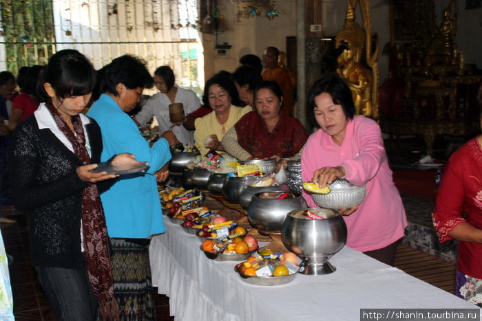 Женщины жертвуют монахам пищу собственного приготовления и магазинную Удон-Тани, Таиланд