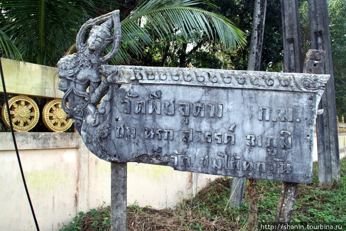 Скульптура с надписью у стены монастыря Трат, Таиланд