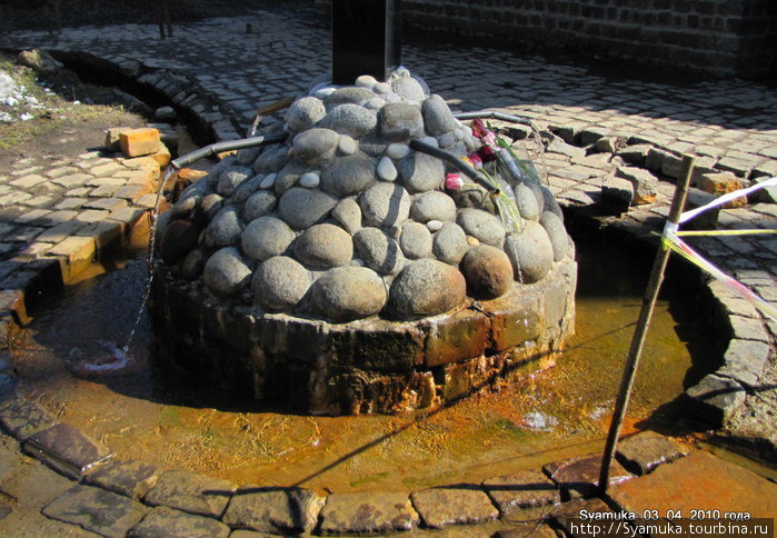 Из камня выложена полусфера, из которой вода источника выведена в 4 трубы на разные стороны. Москва и Московская область, Россия