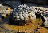 Из камня выложена полусфера, из которой вода источника выведена в 4 трубы на разные стороны.