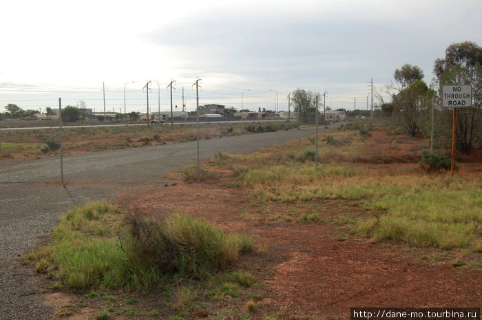 Некогда работающая дорога теперь перегорожена забором Калгурли, Австралия