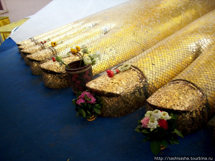 На пальцах ног подношения из цветов. Бангкок, Таиланд