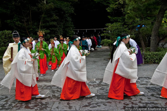 Процессия вышла по направлению к главному зданию храма Камакура, Япония