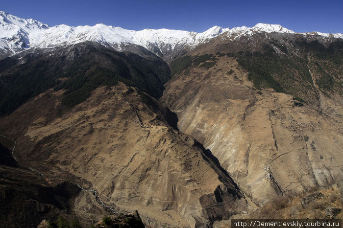 Фотография сделана уже почти с самого верха. На противоположном склоне, снизу, видна нить дороги, оттуда мы бодро шли наверх. Непал