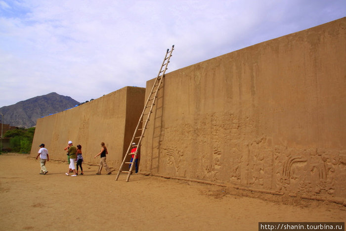 Туристы выходят из ворот храма Трухильо, Перу
