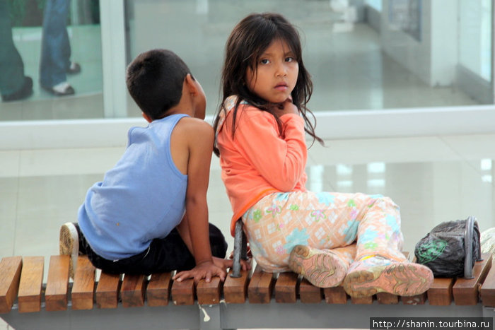 Брат с сестрой на скамейке в новом автовокзале Кито, Эквадор