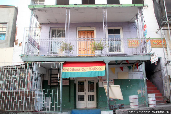 Год благословил наш народ! — надпись на плакате над входом в дом Сент-Джорджес, Гренада