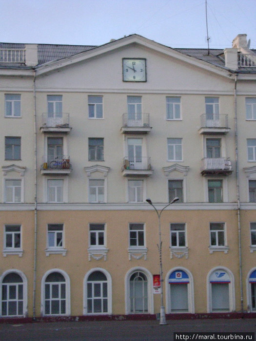 На фасаде здания с ажурными арками окон на первом этаже часы отчетливо показывали 23:54 Северодвинск, Россия
