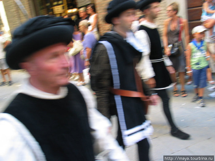 контрады в средневековых костюмах идут на парад Сиена, Италия