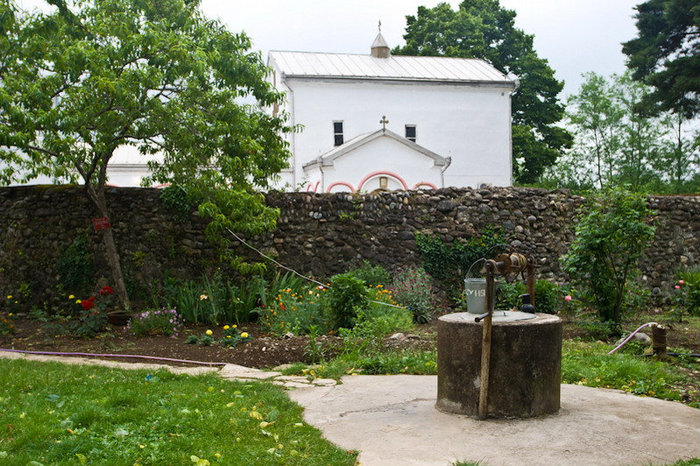 За оградой храма расположен колодец, небольшой огород Илор, Абхазия