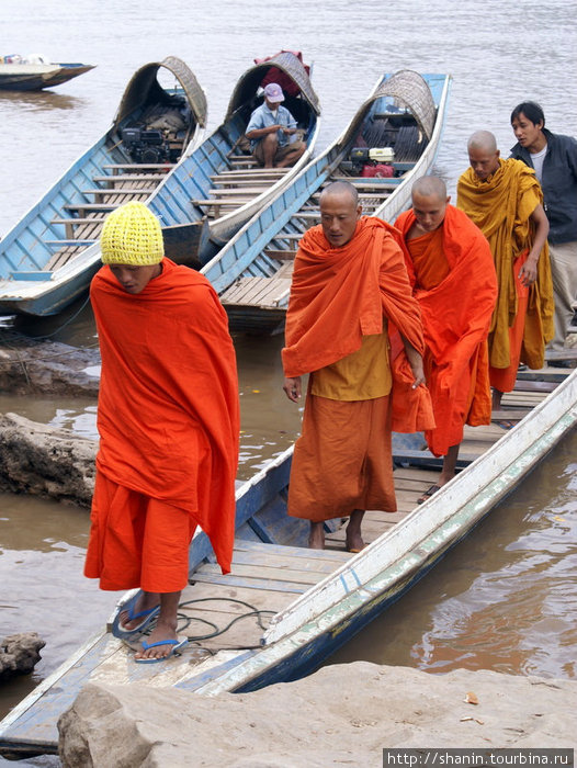 Строем — монахи выходят из лодки Лаос