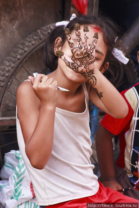Девочка рисует себе на руке; эх, понятия о красоте всегда и везде были разными Катманду, Непал