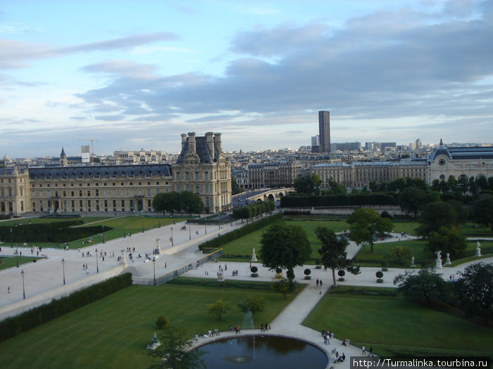 Вид на башню Монпарнас и Лувр с колеса обозрения в саду Тюильри Париж, Франция