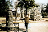 Шаманские столбы (сзади от меня) и божок Тольхарубан с острова Чечжудо (слева).