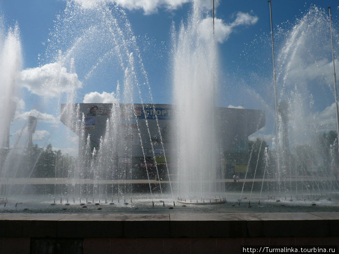 На противоположно стороне улицы находится фонтан, а за ним — Дворец спорта Труд и стадион Труд. Иркутск, Россия