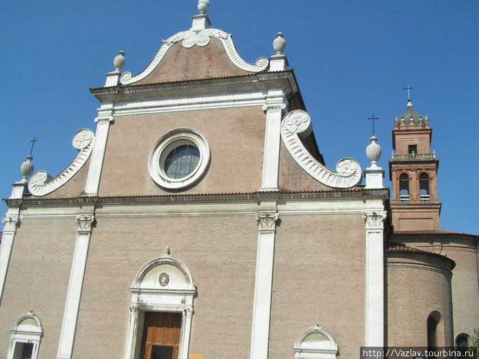 Фасад церкви. На заднем плане видна башня Феррара, Италия
