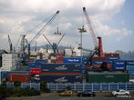 Грузовые краны и корабли, на которые вовсю идет погрузка огромных контейнеров с товарами