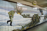 Следующая мозаика — кажется самая большая из ростовских. Она целиком занимает стену перехода и тянется наверное на десяток метров. 
Начало. Раненный солдат подносит снаряды к пушке Зис-3.