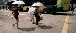 Автобусная остановка рядом с ж/д вокзалом. Девушки укрываются не от дождя, а от солнца. Для китаянок белая кожа атрибут красоты и не только.