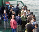 Египетские мужчины плывут на пароме через Суэцкий канал в Порт-Саиде