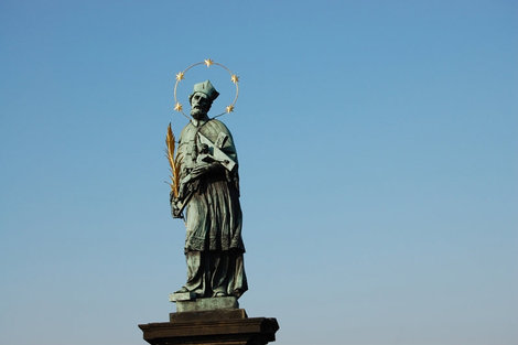 Самая старая и известная скульптура Карлова моста — мученик Ян Непомуцкий. По преданию, в том месте, где он был сброшен в воду, над водой появилось пять звёзд. Прага, Чехия