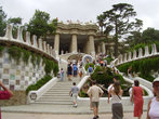 За воротами поднимается широкая лестница с фонтанчиками, гербом Каталонии и огромной мозаичной ящерицей, ставшей одним из символов Барселоны.