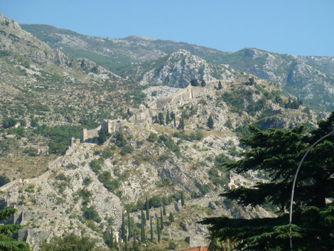Вид на лестницу, ведущую на крепость на горе. Справа вверху видна красноватая точка — флаг Черногории Будва, Черногория