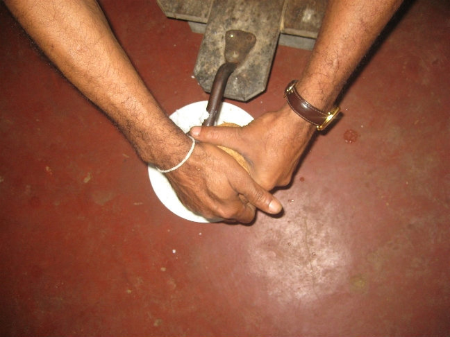 Экскурсовод принялся выскребать кокосовую стружку с помощью специального аппарата. Центральная провинция, Шри-Ланка