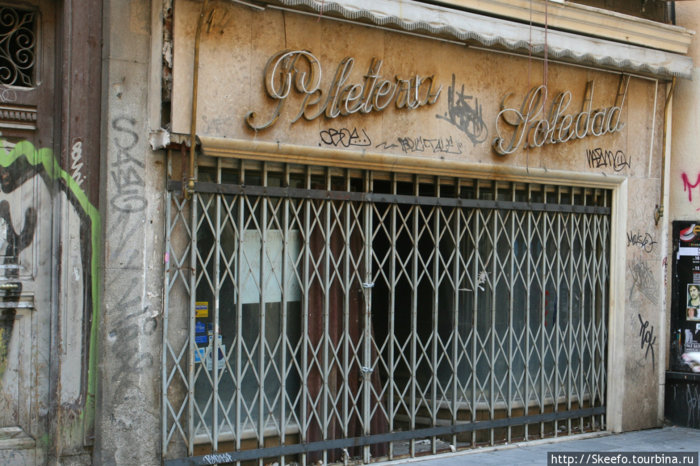 В центре Мадрида спокойно соседствуют ультрамодный бутик и нечто непонятное, все в граффити с древней вывеской. Мадрид, Испания