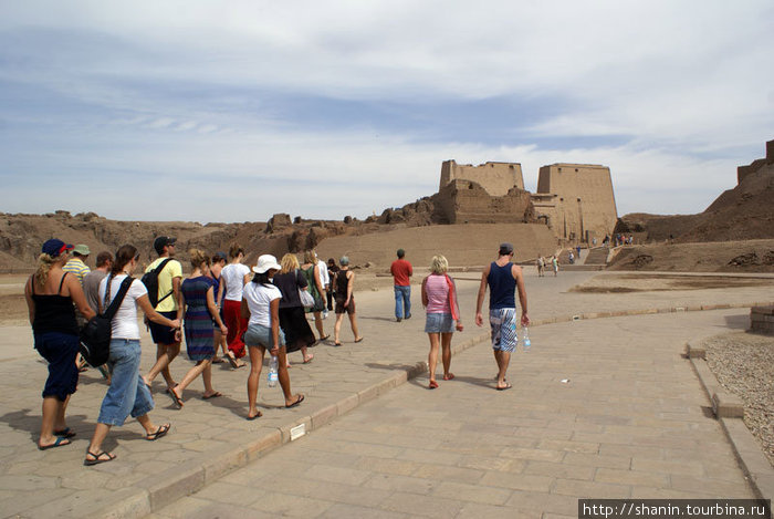 Туристы идут к входу в храм Гора в Эдфу Провинция Асуан, Египет