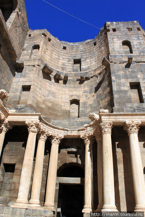 Колонны на сцене и стена амфитеатра Босра, Сирия