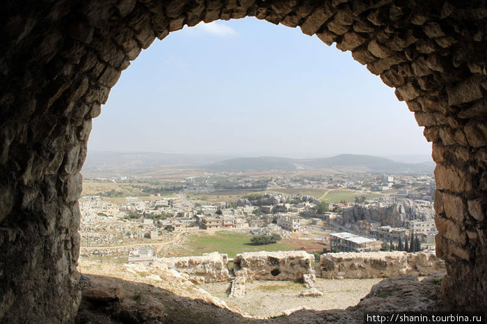 Вид на город через арку из замка Масиаф Сирия