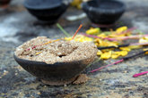 Ароматные палочки и глиняные чаши для жертвоприношений перед изображением Будды
