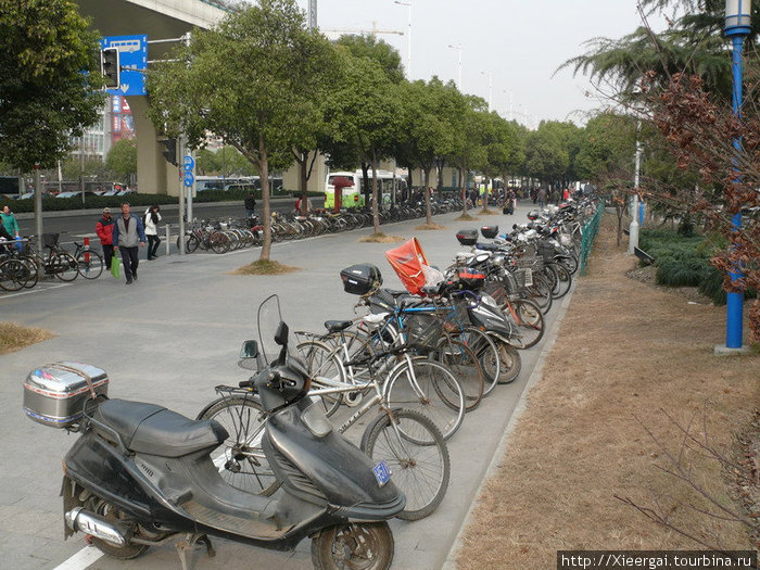 Повсеместно расположены парковки для вело-мото транспорта. Шанхай, Китай